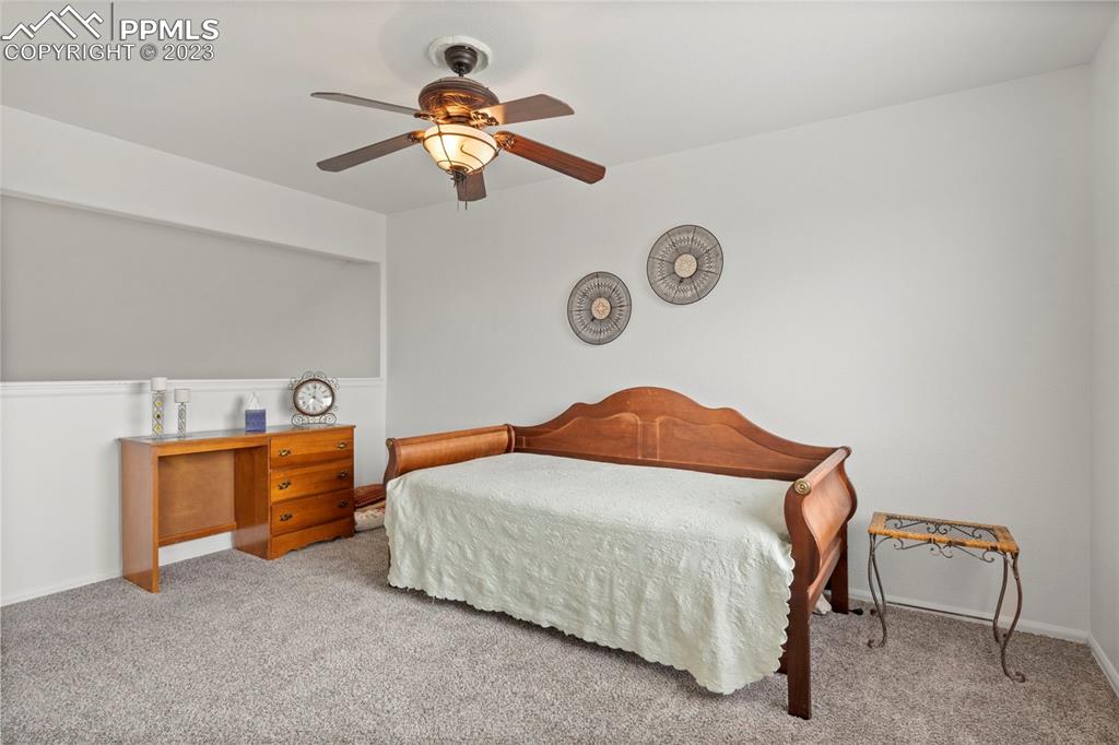 11916 Bonifay Loop Peyton, CO 80831 - Photo 20 of 42 a bedroom with a bed and a chandelier