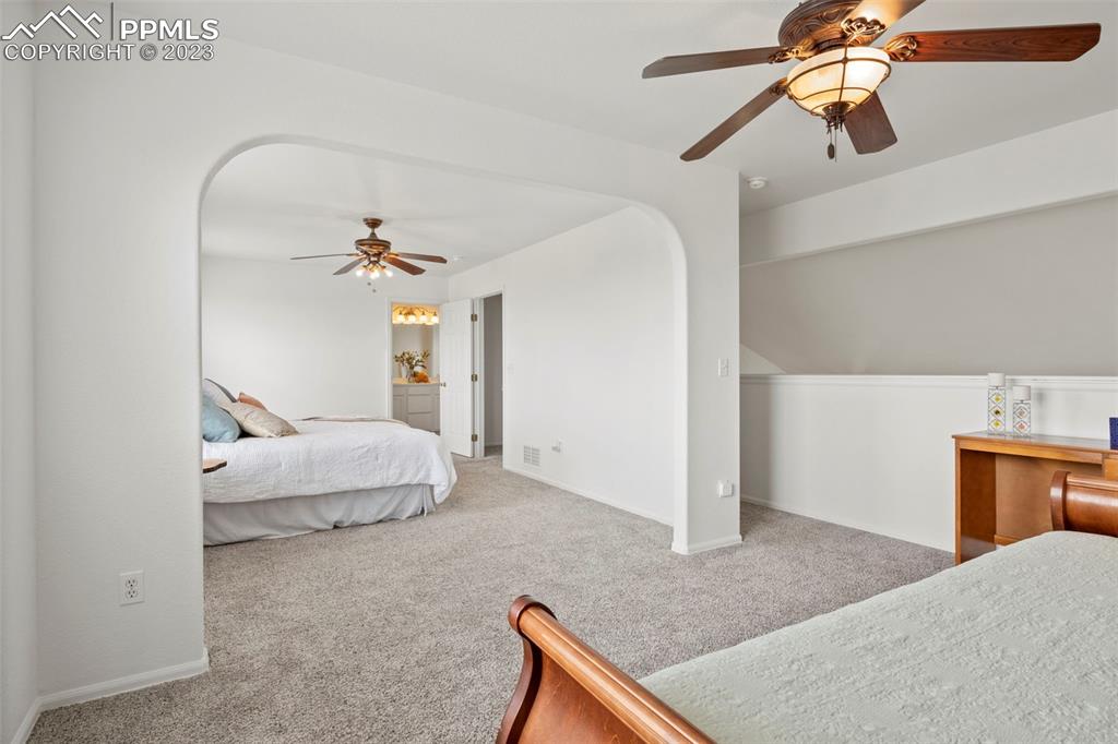 11916 Bonifay Loop Peyton, CO 80831 - Photo 21 of 42 a bedroom with a bed and a chandelier