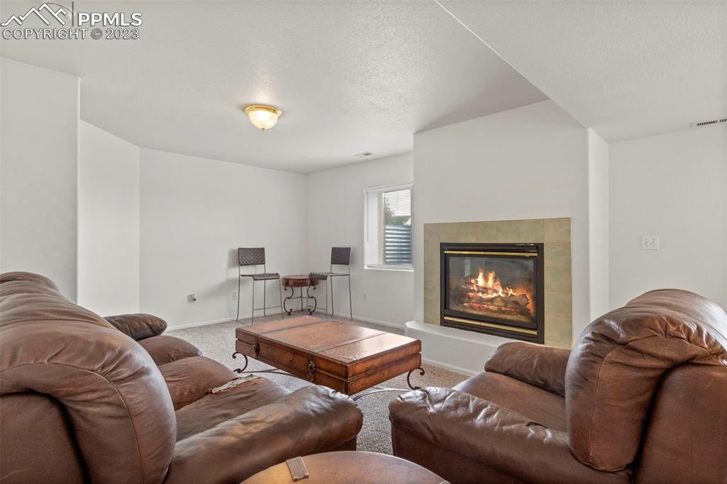 11916 Bonifay Loop Peyton, CO 80831 - Photo 27 of 42 a living room with furniture and a fireplace