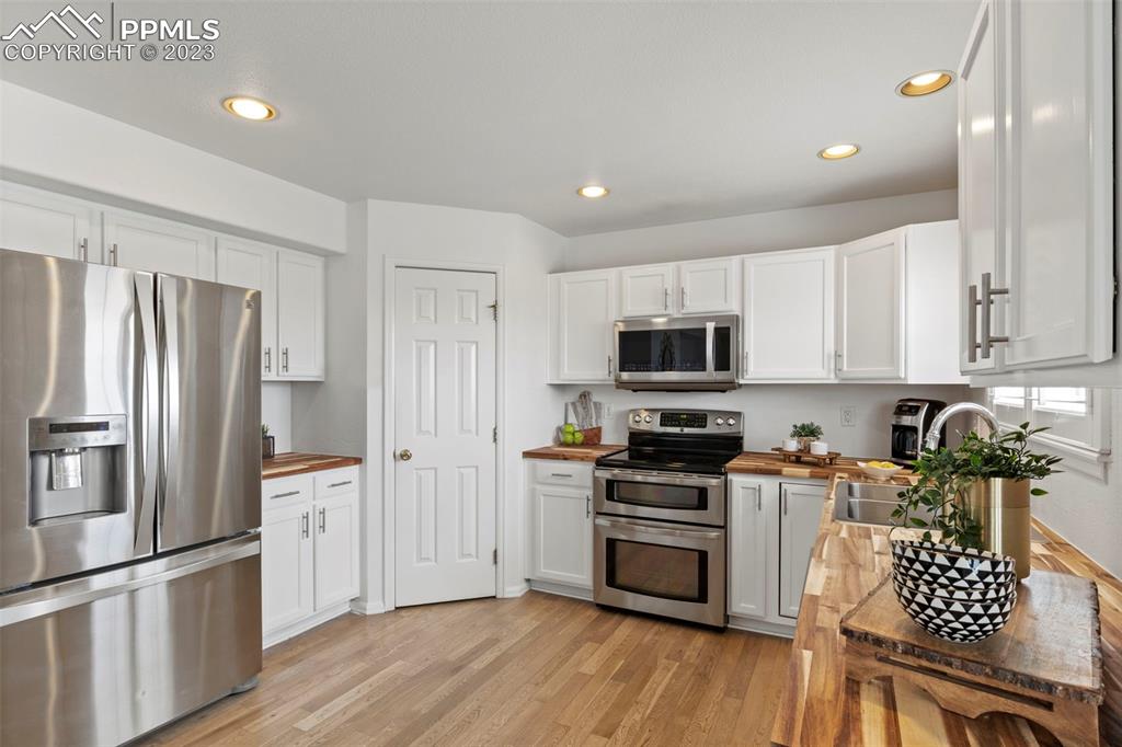 11916 Bonifay Loop Peyton, CO 80831 - Photo 9 of 42 a kitchen with stainless steel appliances a refrigerator sink and stove top oven