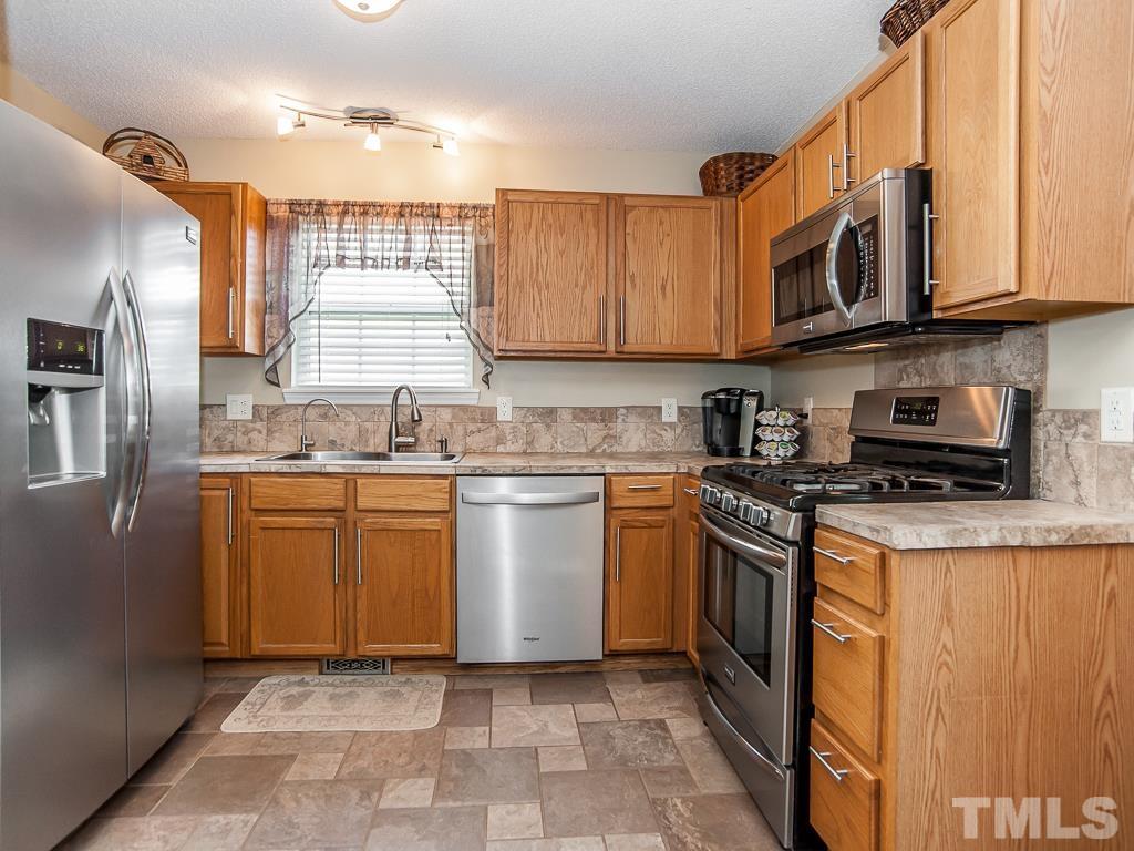 4217 Mardela Spring Drive Raleigh, NC 27616 - Photo 11 of 26 a kitchen with stainless steel appliances granite countertop a stove sink and cabinets