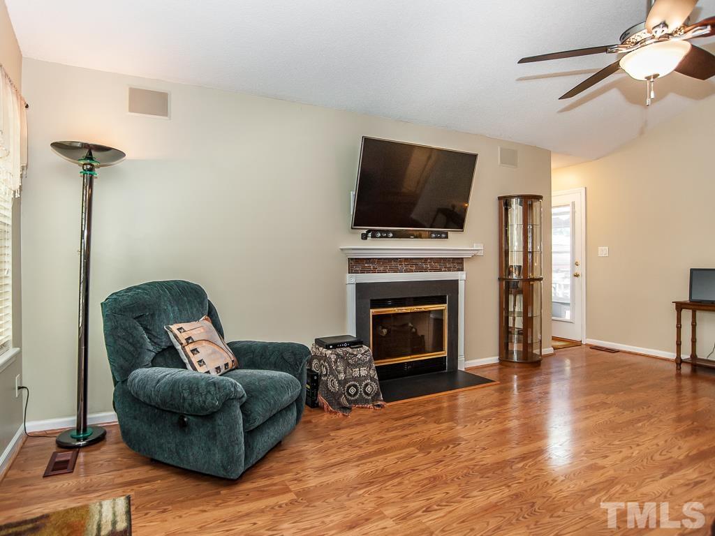 4217 Mardela Spring Drive Raleigh, NC 27616 - Photo 9 of 26 a living room with furniture a flat screen tv and a fireplace