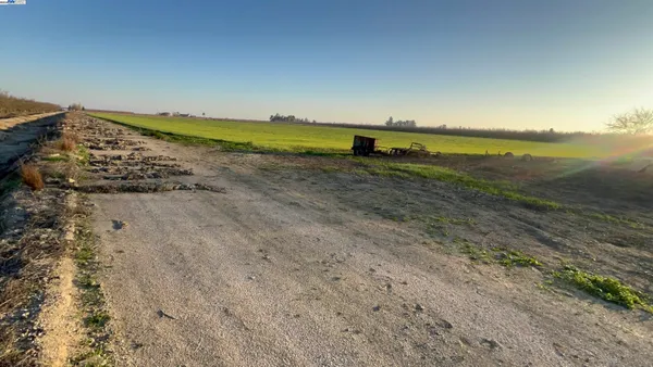 a view of a lake with a table and chairs under an umbrella