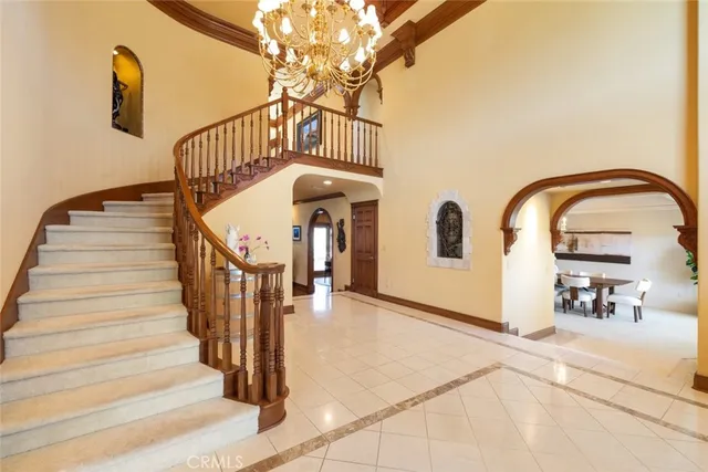 a view of a dining room with furniture a chandelier and a large window