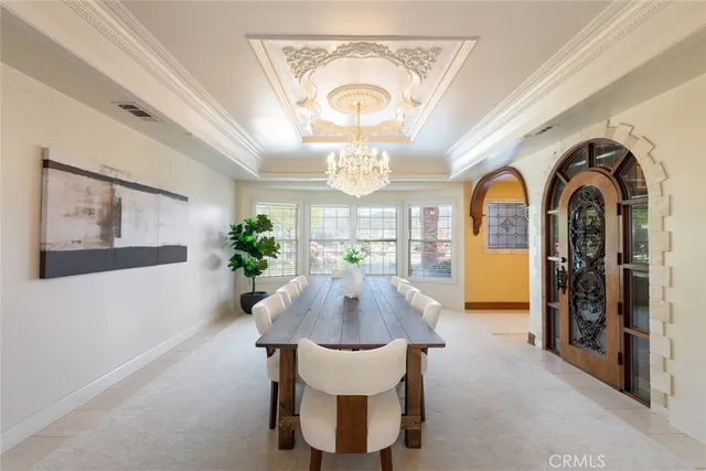 a view of a dining room with furniture a chandelier and wooden floor
