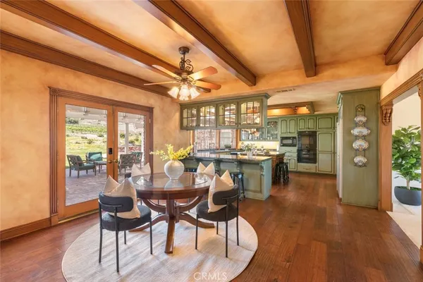 a view of a dining room with furniture a chandelier and wooden floor