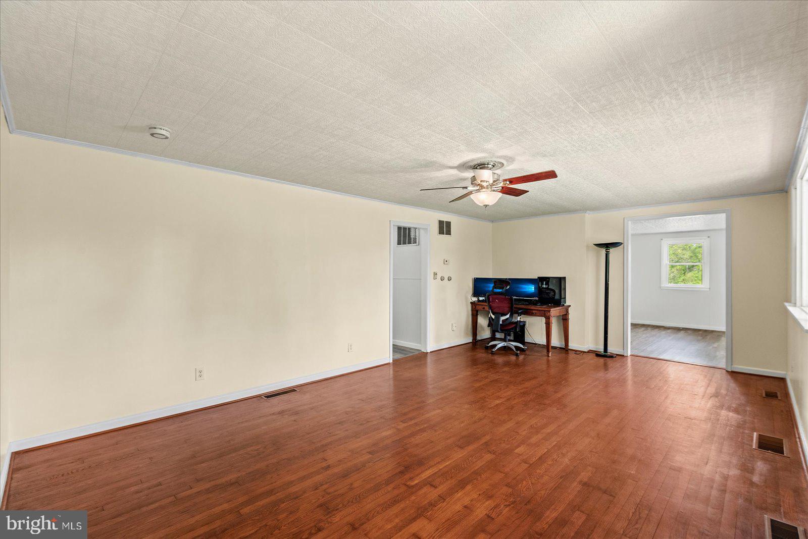 679 Resettlement Road Madison, VA 22727 - Photo 17 of 47 a view of an empty room with wooden floor and a ceiling fan