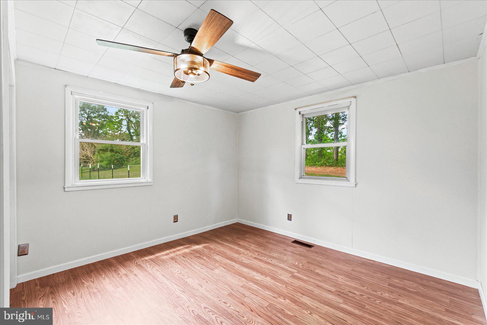 679 Resettlement Road Madison, VA 22727 - Photo 21 of 47 an empty room with wooden floor ceiling fan and window