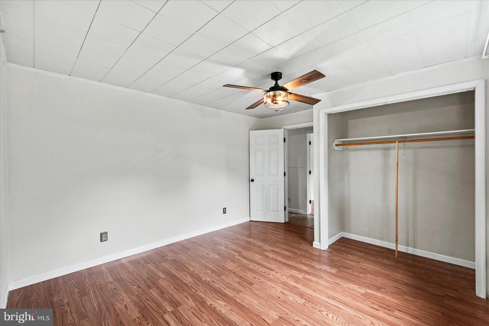 679 Resettlement Road Madison, VA 22727 - Photo 22 of 47 an empty room with wooden floor and a ceiling fan