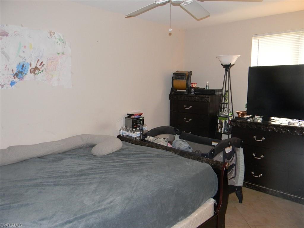 4448 30th Place Southwest Naples, FL 34116 - Photo 11 of 19 a bedroom with a bed and a flat screen tv