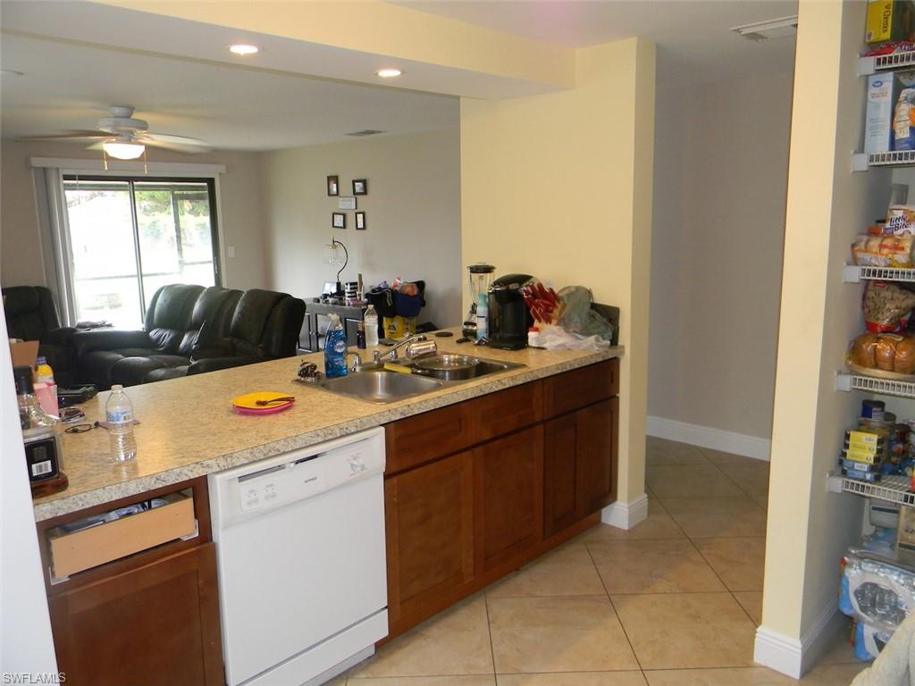 4448 30th Place Southwest Naples, FL 34116 - Photo 3 of 19 a kitchen with a sink and cabinets