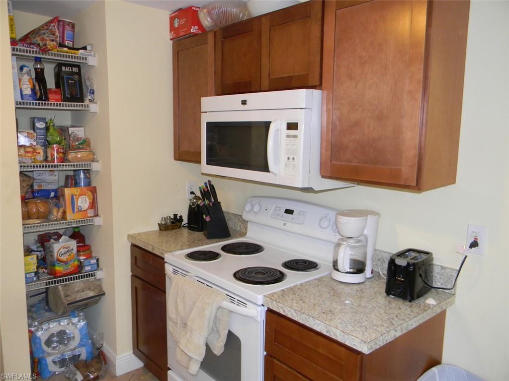 4448 30th Place Southwest Naples, FL 34116 - Photo 4 of 19 a kitchen with a stove and a microwave