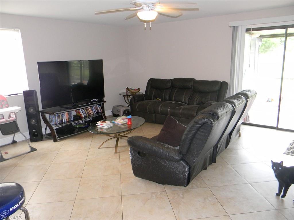 4448 30th Place Southwest Naples, FL 34116 - Photo 6 of 19 a living room with furniture and a flat screen tv