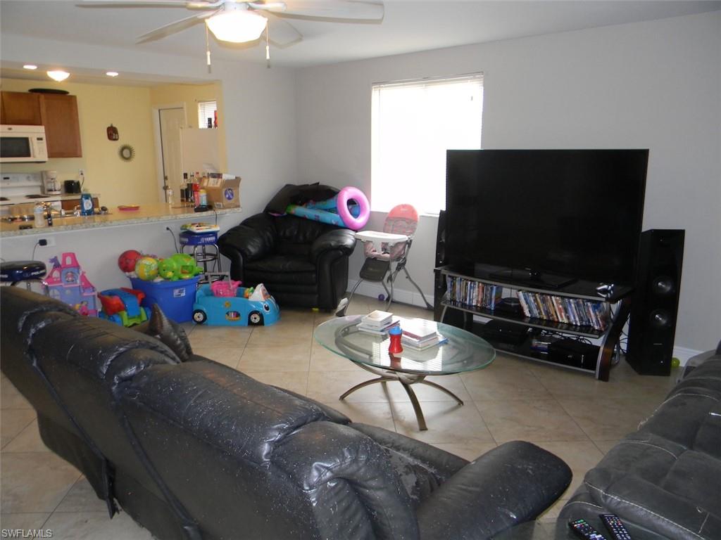 4448 30th Place Southwest Naples, FL 34116 - Photo 7 of 19 a living room with furniture and a flat screen tv