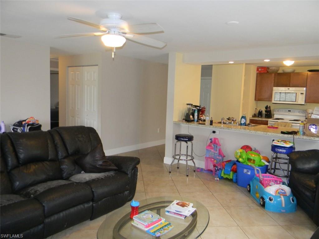 4448 30th Place Southwest Naples, FL 34116 - Photo 8 of 19 a living room with furniture and a chandelier