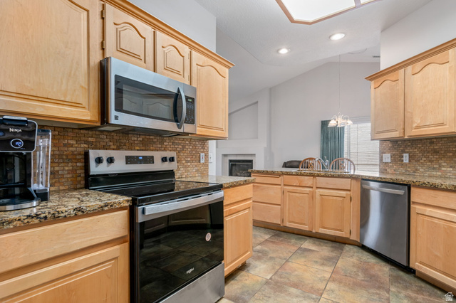 39 North Valley View Drive, Unit 51 St. George, UT 84770 - Photo 12 of 25 Kitchen featuring wood cabinetry, granite-finish countertops, and a mosaic tile backsplash