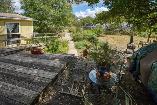 a living room with furniture a flat screen tv and a refrigerator