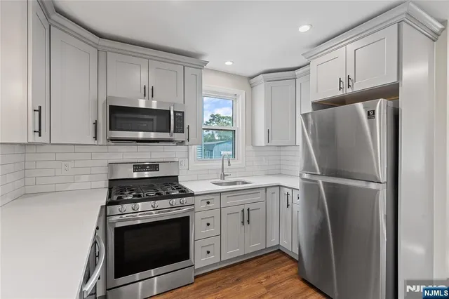 a kitchen with stainless steel appliances a refrigerator stove and microwave