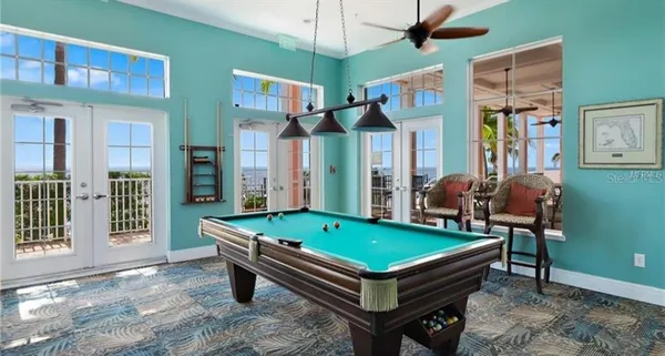 a room with pool table and windows