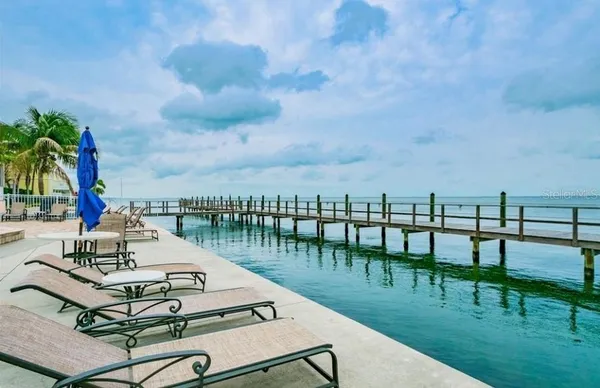 a view of a lake with couches chairs and a table and chairs