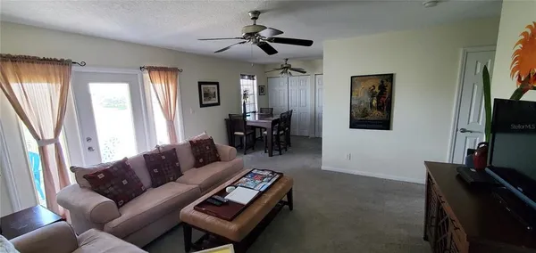 a living room with furniture a ceiling fan and a window