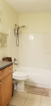a bathroom with a granite countertop toilet a sink and a shower