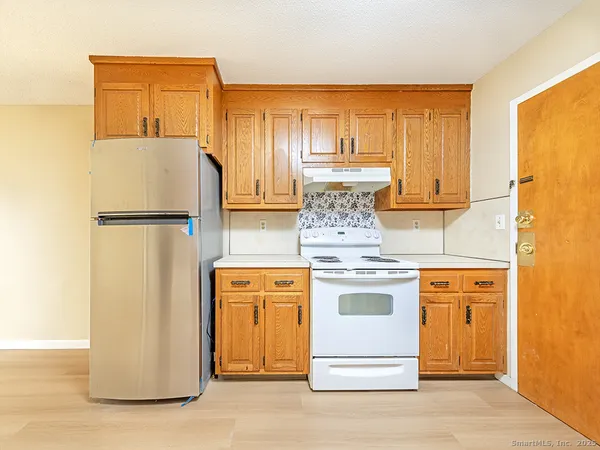 a kitchen with a refrigerator sink stove and cabinets