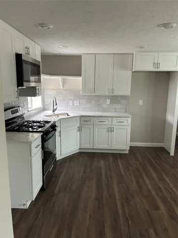 a kitchen with stainless steel appliances granite countertop a stove and a sink