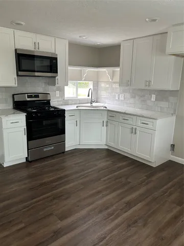 a kitchen with granite countertop a stove and a microwave