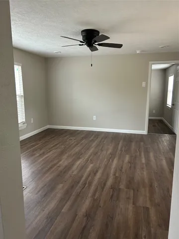 a view of an empty room with wooden floor