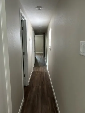 a view of a hallway with wooden floor