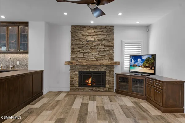a living room with stainless steel appliances granite countertop furniture a fireplace and a window
