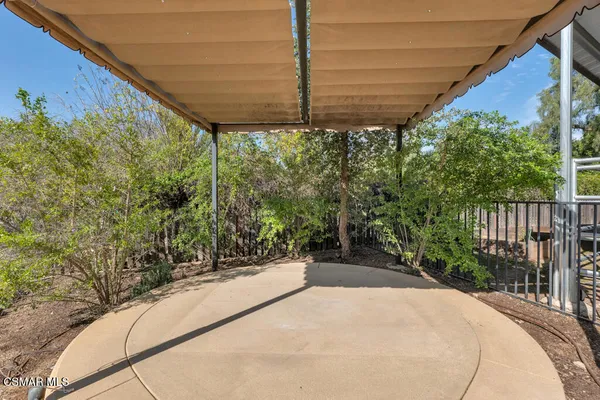 a view of a backyard with floor to ceiling window and wooden fence