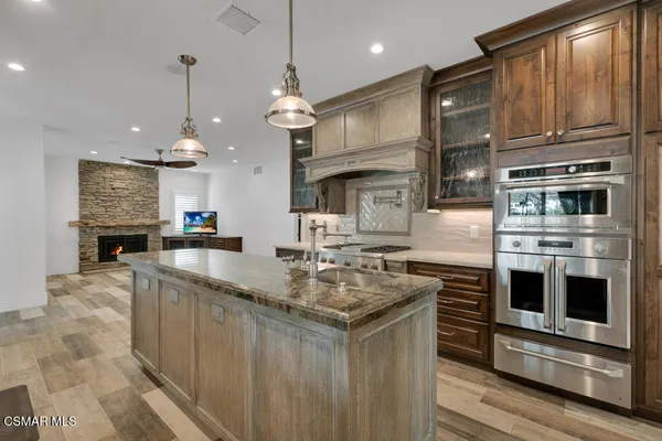 a kitchen with stainless steel appliances granite countertop a stove a sink and a refrigerator
