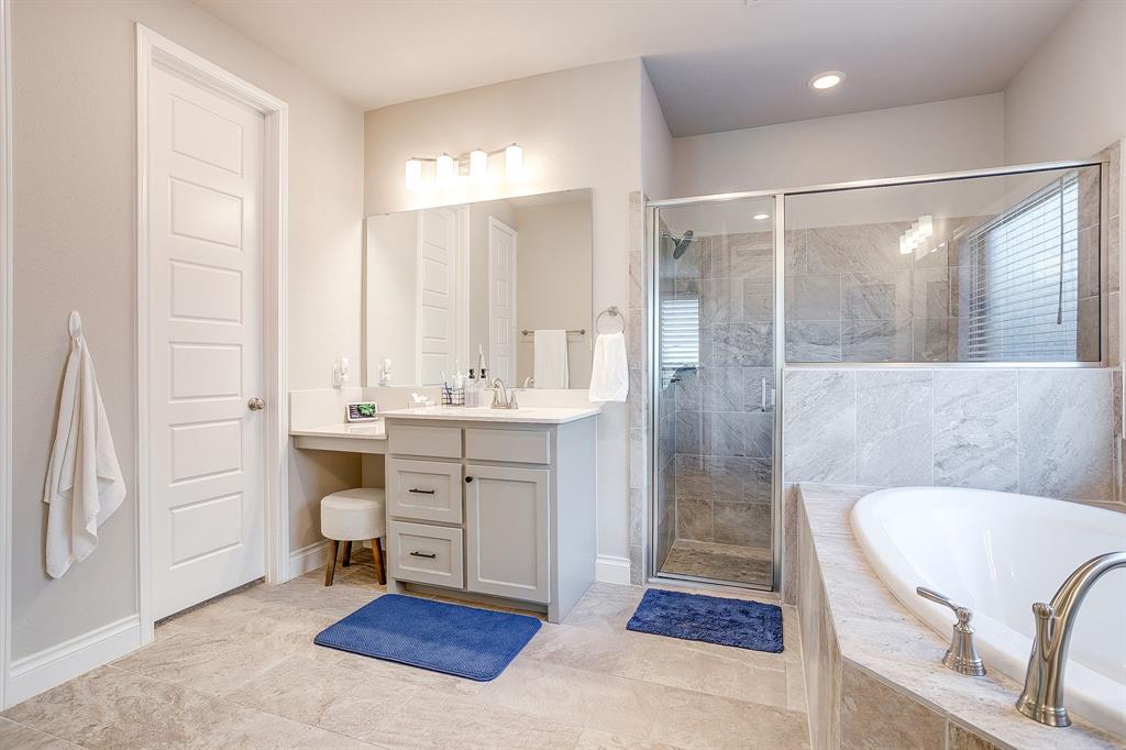5709 Pope Creek Road Fort Worth, TX 76126 - Photo 21 of 39 A spacious walk-in shower and a second vanity with a built-in seating area add both comfort and functionality to the space.