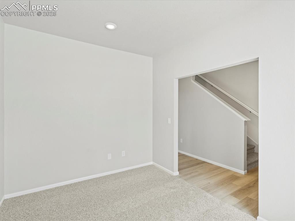 10636 Waterloo Drive Peyton, CO 80831 - Photo 15 of 36 Spare room featuring stairs, recessed lighting, carpet, and baseboards