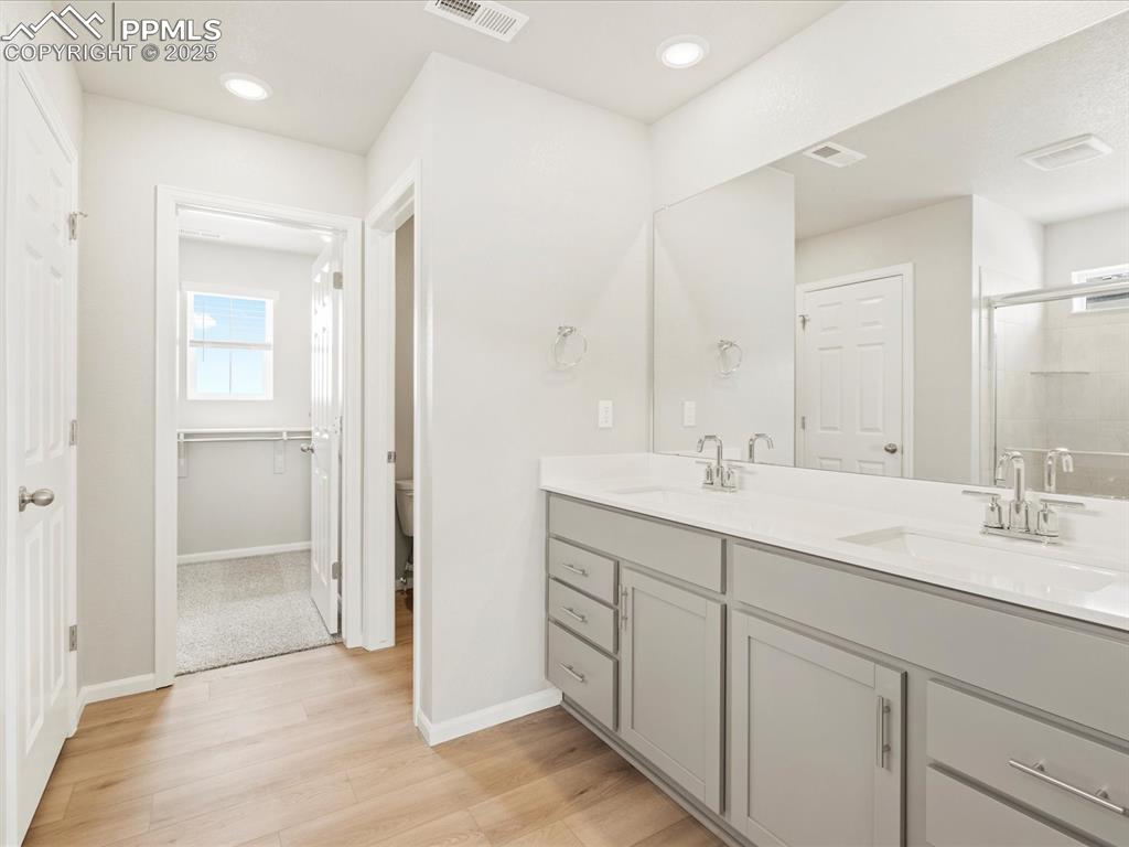 10636 Waterloo Drive Peyton, CO 80831 - Photo 23 of 36 Full bathroom featuring double vanity, visible vents, a shower stall, and a sink
