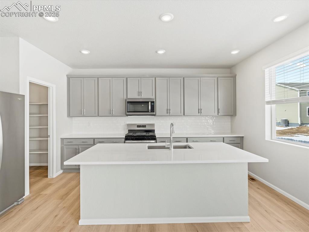 10636 Waterloo Drive Peyton, CO 80831 - Photo 3 of 36 Kitchen featuring gray cabinetry, stainless steel appliances, light countertops, and a sink