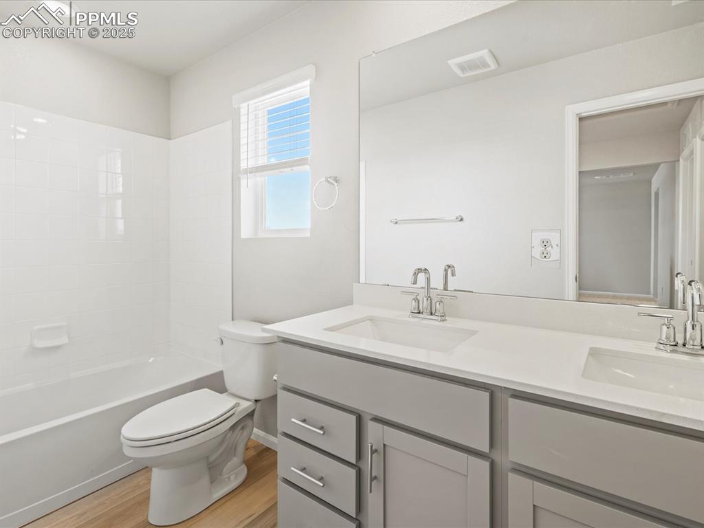 10636 Waterloo Drive Peyton, CO 80831 - Photo 34 of 36 Full bathroom featuring visible vents, toilet, wood finished floors, and a sink