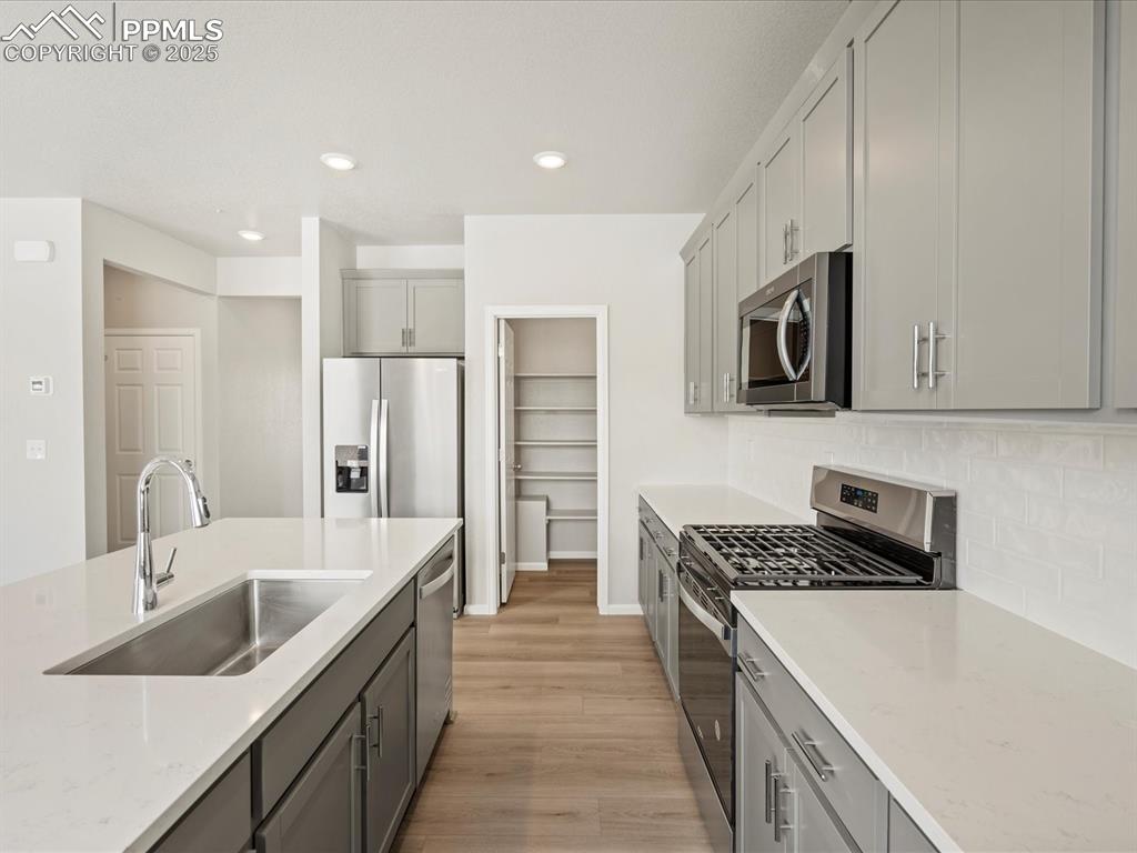 10636 Waterloo Drive Peyton, CO 80831 - Photo 7 of 36 Kitchen with gray cabinets, stainless steel appliances, and a sink