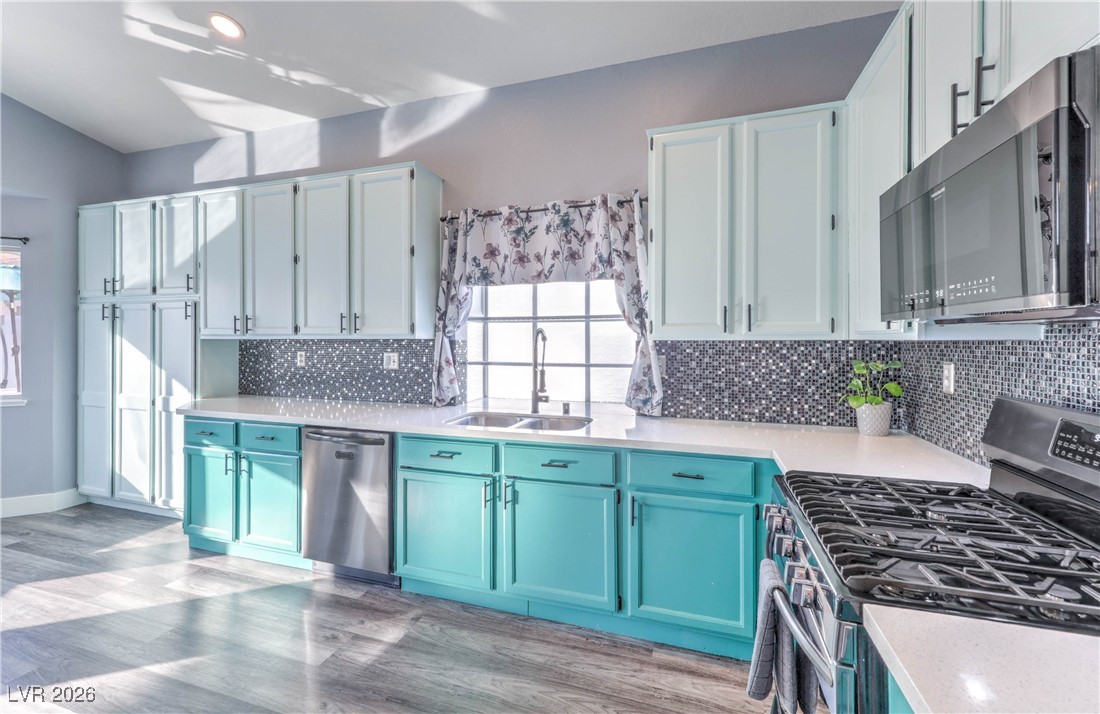 9405 Crosspointe Avenue Las Vegas, NV 89117 - Photo 16 of 37 Upgraded kitchen with Quartz countertops, Backsplash, Black Stainless Appliances, and Painted Cabinets w/ ton of storage!
