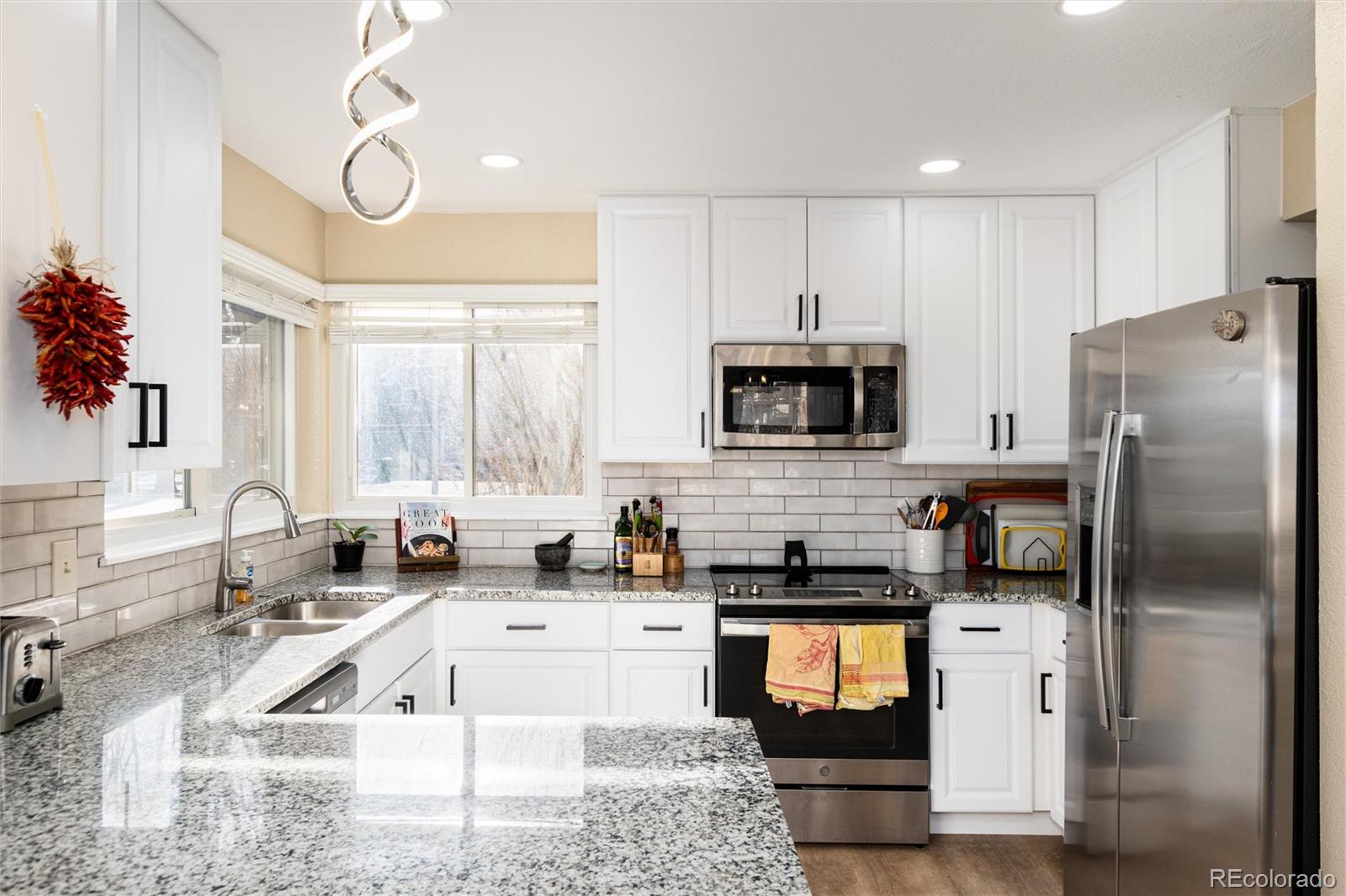 4010 South Rifle Way Aurora, CO 80013 - Photo 17 of 45 a kitchen with granite countertop a refrigerator stove and sink