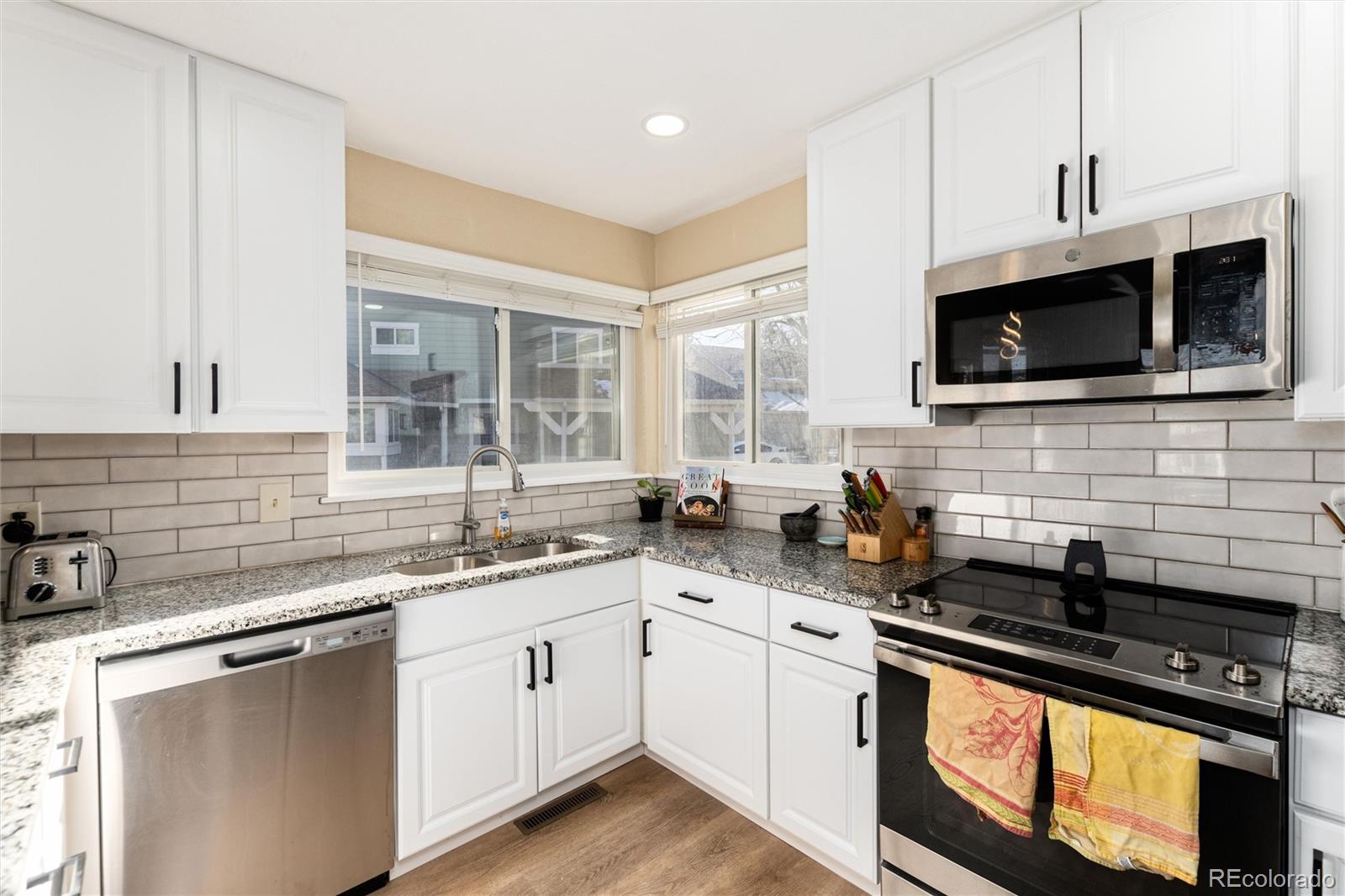 4010 South Rifle Way Aurora, CO 80013 - Photo 19 of 45 a kitchen with stainless steel appliances a sink stove and microwave