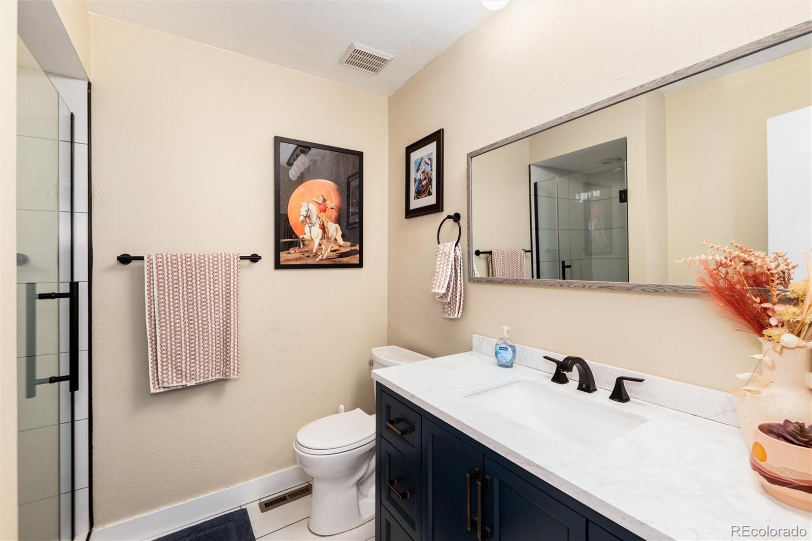 4010 South Rifle Way Aurora, CO 80013 - Photo 22 of 45 a bathroom with a toilet sink vanity and mirror
