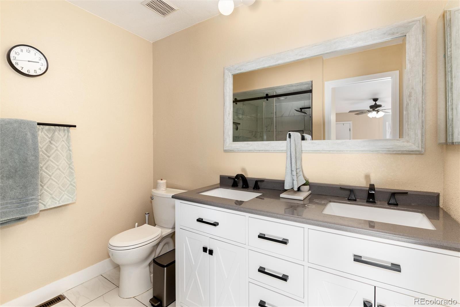 4010 South Rifle Way Aurora, CO 80013 - Photo 26 of 45 a bathroom with a granite countertop toilet sink and mirror
