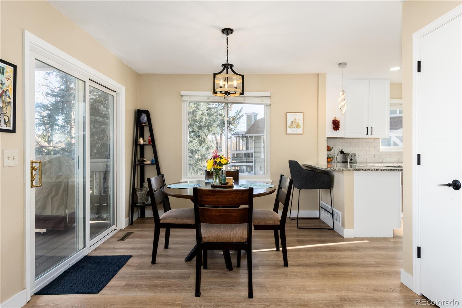4010 South Rifle Way Aurora, CO 80013 - Photo 7 of 45 a dining room with furniture a chandelier and wooden floor