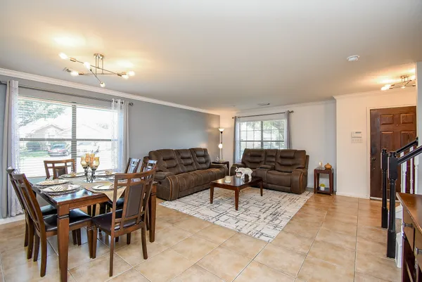 a living room with furniture a rug and kitchen view