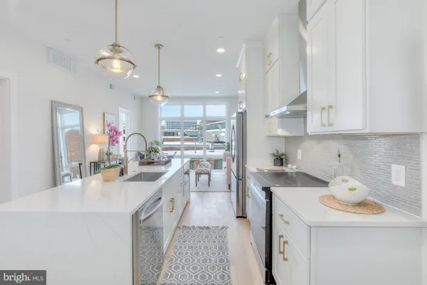a kitchen with kitchen island a sink appliances and cabinets