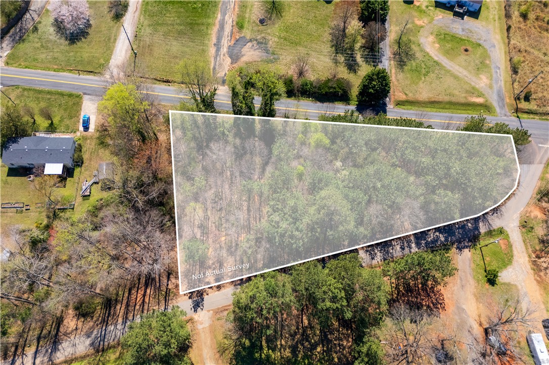 This aerial view showcases a verdant lot, ideal for new construction amidst a natural setting.