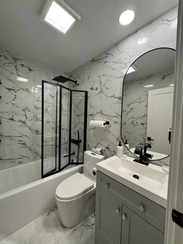 a bathroom with a sink a toilet and shower